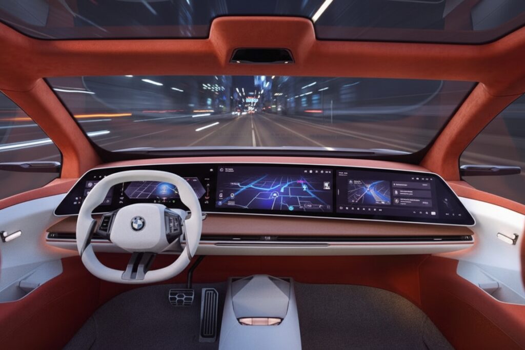 Futuristic BMW interior showing a wide digital dashboard with navigation displays while driving through a city at night.